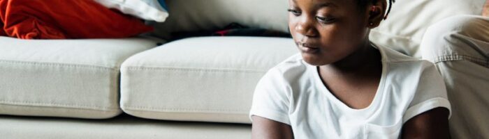 sad black girl sitting at sofa