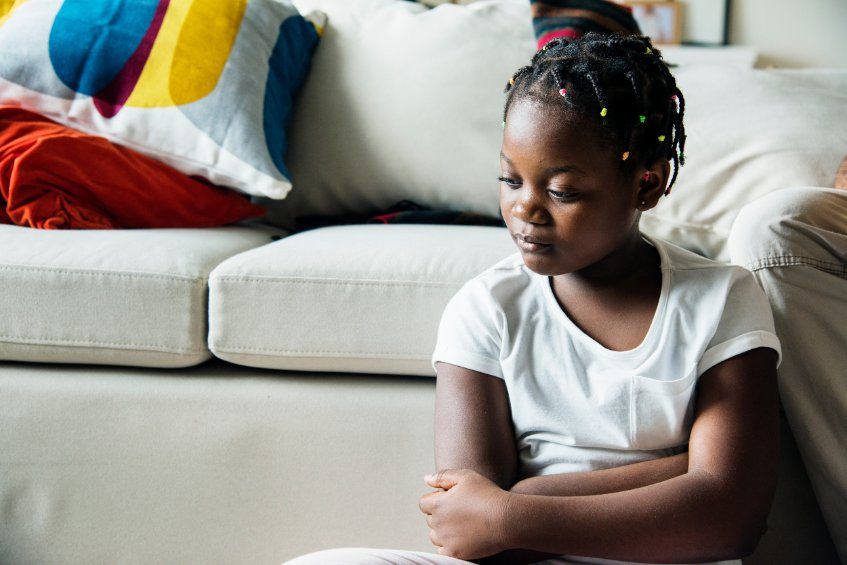 sad black girl sitting at sofa