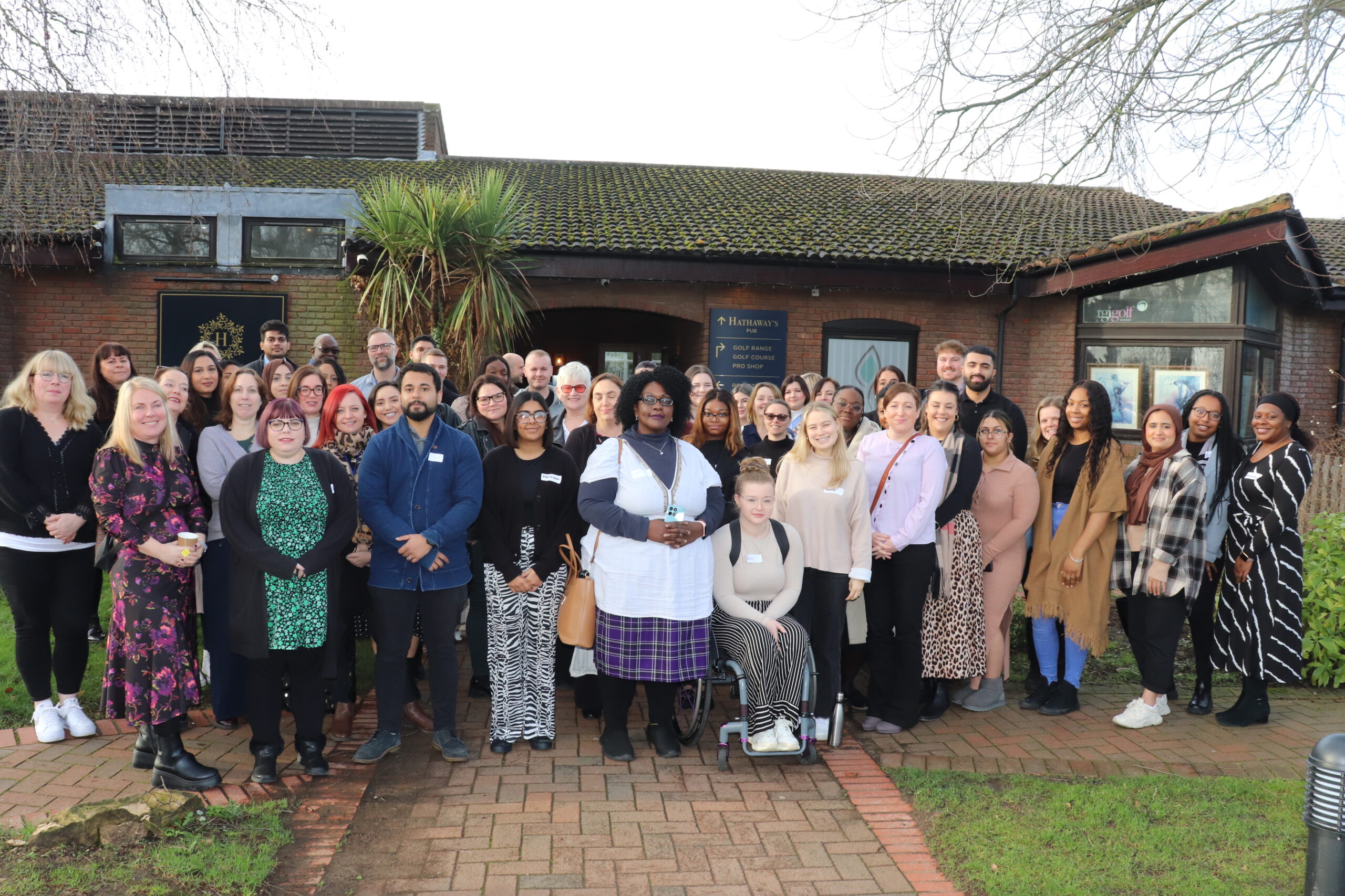 A large, diverse group of people smiling for a photograph.