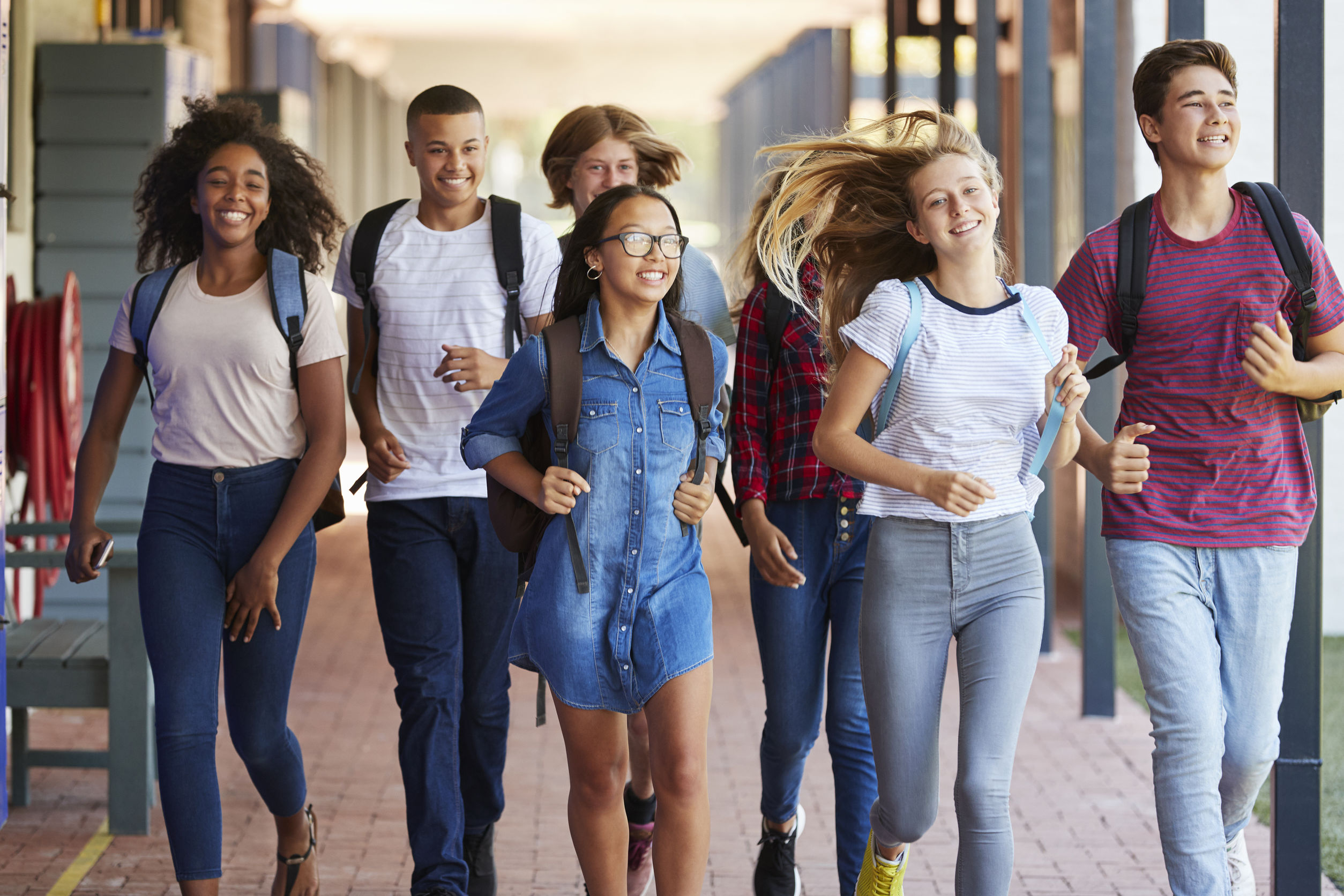 A group of teenagers walking together through a school.